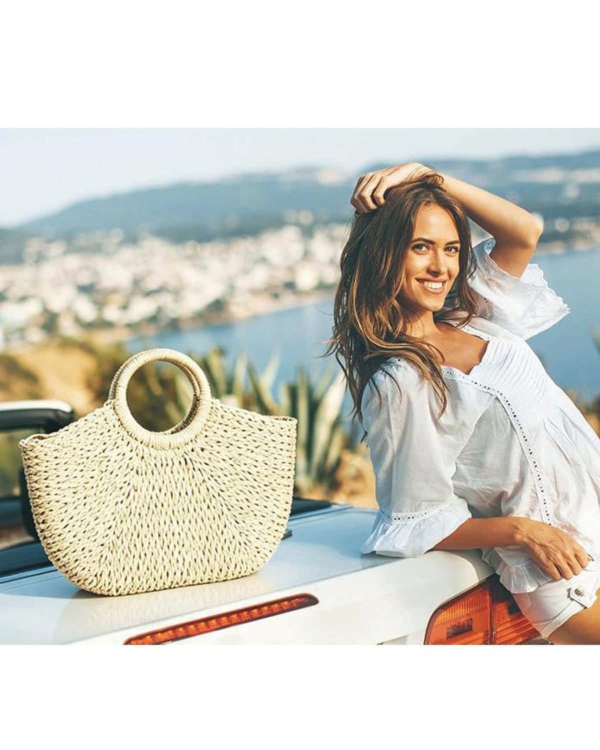 Shopper with a hand-woven straw bag on a sunny coastal road